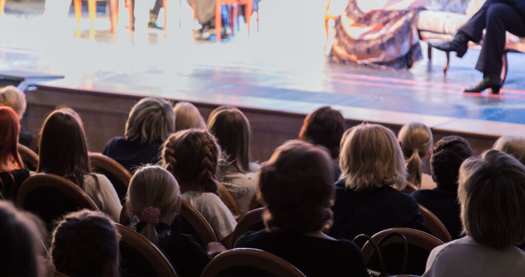 audience and stage with blurry view of actors