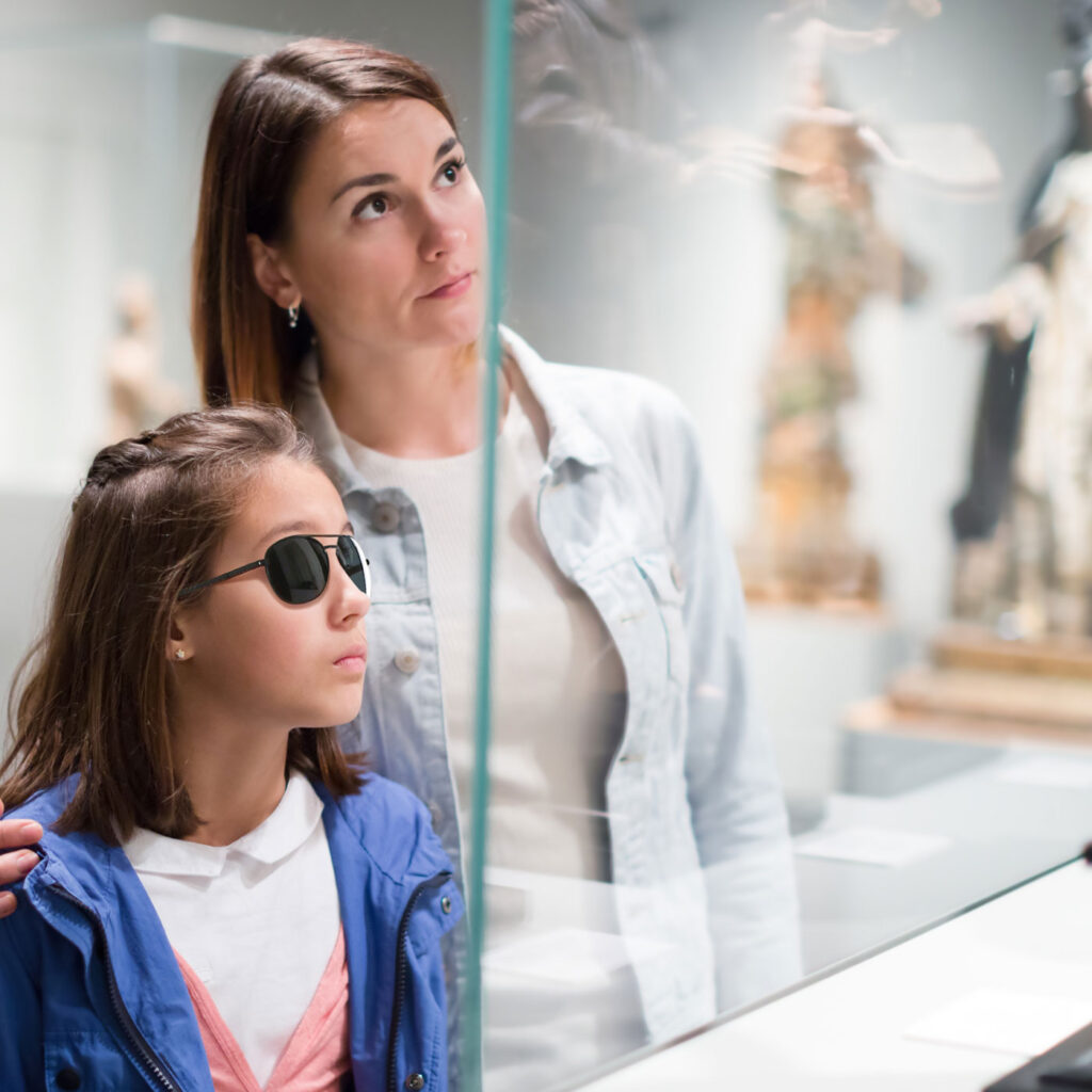 Young woman and child with sunglasses in front of a display